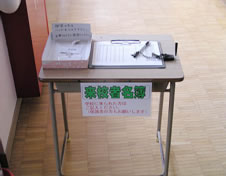 4．事務室横に置かれている来校者名簿と来校者バッジ