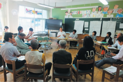 社会に開かれた教育課程の実現に向けて，地域住民とともに行った授業についての振り返りをしている様子（島根県益田市立豊川小学校）