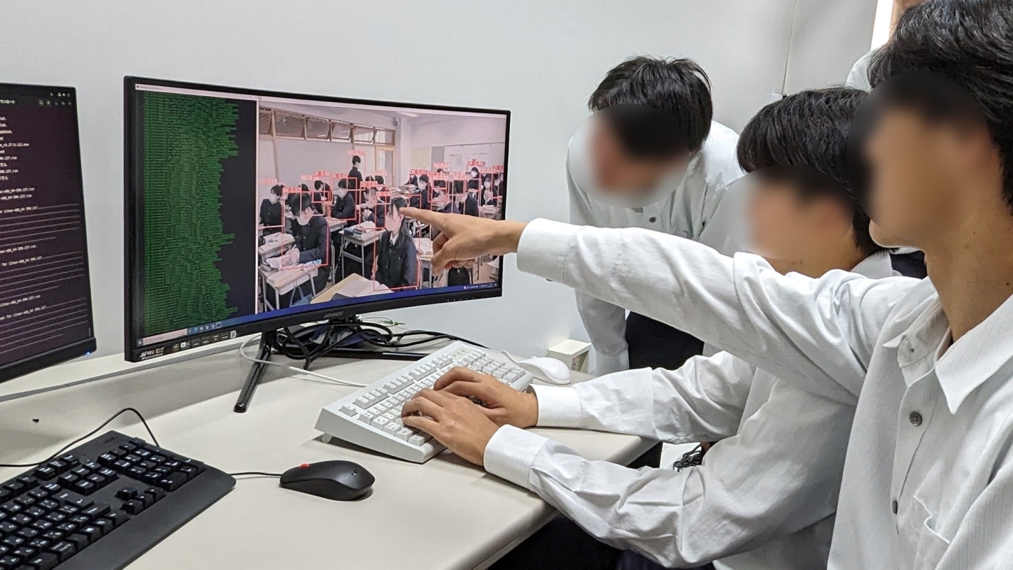 コンピュータ画面に向かい話し合う生徒の様子