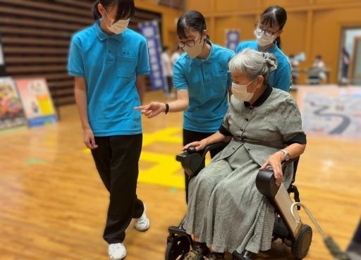 電動車椅子WHILLの操作を紹介する生活福祉科の生徒。鹿児島県立加世田常潤高等学校では、こうした先端機器を地域のイベント等で活用している。利用した方々からは「試乗の機会があってよかった」「家族のために購入方法を知りたい」といった声が寄せられた。単に機器の紹介に留まらず、介護保険の適用に関する情報提供も行うなど、鹿児島県立加世田常潤高等学校が地域への情報発信の拠点にもなっている。